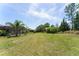 Expansive backyard features lush grass, mature landscaping, and a screened lanai for outdoor enjoyment at 7855 Sw 97Th Cir, Ocala, FL 34481