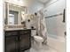 Bathroom features granite countertops, a decorative mirror, and a shower/tub combo with modern fixtures at 7855 Sw 97Th Cir, Ocala, FL 34481