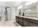 Bright bathroom featuring a double vanity with granite countertop and a large mirror with great lighting at 7855 Sw 97Th Cir, Ocala, FL 34481