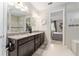 Bright bathroom featuring a double vanity with granite countertop and an entrance to the main bedroom at 7855 Sw 97Th Cir, Ocala, FL 34481