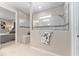 Bright bathroom with glass-enclosed shower, convenient bench, and neutral tile, creating a relaxing and modern space at 7855 Sw 97Th Cir, Ocala, FL 34481