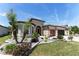 Lovely house with a vibrant garden, swaying palm trees, and a warm, welcoming facade with a two-car garage at 7855 Sw 97Th Cir, Ocala, FL 34481