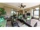 Inviting covered lanai with multiple seating areas, ceiling fan, and access to outdoor kitchen at 7855 Sw 97Th Cir, Ocala, FL 34481