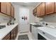 Functional laundry room featuring modern appliances, ample counter space, and built-in storage cabinets at 7855 Sw 97Th Cir, Ocala, FL 34481