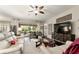 Cozy living room with plush white sofas, a decorative ceiling fan, and a sliding glass door to the outdoor patio at 7855 Sw 97Th Cir, Ocala, FL 34481