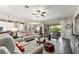 Open-concept living room showcasing comfortable seating, a ceiling fan, and views of the lanai through sliding glass doors at 7855 Sw 97Th Cir, Ocala, FL 34481