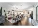 Expansive open-concept living space featuring dark wood floors, white kitchen, and comfortable living room furniture at 7855 Sw 97Th Cir, Ocala, FL 34481