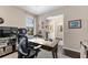 Bright home office featuring a large desk, comfortable chair, window with blinds, and modern decor elements at 7855 Sw 97Th Cir, Ocala, FL 34481