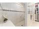 Bright walk-in shower with neutral tile and mosaic accents offers accessibility and a spa-like experience at 7855 Sw 97Th Cir, Ocala, FL 34481