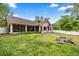 Home's back exterior has a screened in porch along the length of the house, and a white fence at 8221 Sw 217 Ct, Dunnellon, FL 34431