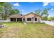 Home's back exterior has a screened in porch along the length of the house, and a white fence at 8221 Sw 217 Ct, Dunnellon, FL 34431