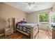 Comfortable bedroom featuring wood-look floors, a large window, a ceiling fan and warm, neutral walls at 8221 Sw 217 Ct, Dunnellon, FL 34431