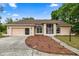 Charming single-story home with a manicured lawn, landscape lighting and a two-car garage at 8221 Sw 217 Ct, Dunnellon, FL 34431