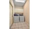 Functional laundry room with washer, dryer, neutral paint, tile flooring and above cabinet storage at 8221 Sw 217 Ct, Dunnellon, FL 34431