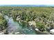 An aerial view of a river lined with houses, docks and trees filled with swimmers at 8221 Sw 217 Ct, Dunnellon, FL 34431