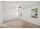 Bright bedroom featuring neutral carpet, a ceiling fan, and multiple windows at 8546 Sw 79Th Ave, Ocala, FL 34476