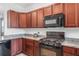 Kitchen boasts wood cabinets, granite countertops, and modern black appliances at 8546 Sw 79Th Ave, Ocala, FL 34476