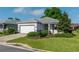 Charming single-story home featuring a manicured front yard, gray exterior paint, and a two-car garage at 8546 Sw 79Th Ave, Ocala, FL 34476