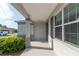 Covered front porch with gray support columns, decorative windows, and landscaping at 8546 Sw 79Th Ave, Ocala, FL 34476
