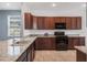 Kitchen features granite countertops, stainless steel appliances, tile flooring and dark wood cabinets at 8546 Sw 79Th Ave, Ocala, FL 34476