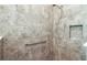 Close up of modern shower with textured gray tile and a niche for storage at 8546 Sw 79Th Ave, Ocala, FL 34476