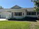 A home's exterior showcasing well-kept grass, plants, and decorative woodwork on the front porch and roof at 8680 Sw 94Th St # D, Ocala, FL 34481