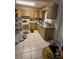 A full view of the kitchen features tiled flooring and a cooking range with light wood cabinets and white countertops at 8680 Sw 94Th St # D, Ocala, FL 34481