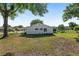 A spacious backyard features a well-maintained lawn and a partially shaded view of the home's exterior at 8851 Sw 116Th Street Rd, Ocala, FL 34481