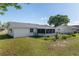 Home's fenced backyard features a well-kept lawn and a screened-in lanai for outdoor enjoyment at 8851 Sw 116Th Street Rd, Ocala, FL 34481