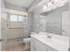 Bright bathroom featuring a shower and vanity with sink and ample mirror at 8851 Sw 116Th Street Rd, Ocala, FL 34481