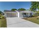 Well-maintained single-story home featuring a screened two-car garage and a cozy front porch at 8851 Sw 116Th Street Rd, Ocala, FL 34481