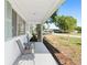 Inviting front porch with seating, landscaped garden beds, and a view of the quiet neighborhood street at 8851 Sw 116Th Street Rd, Ocala, FL 34481