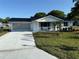 Charming single-story home with a well-manicured lawn, light-colored driveway, and two-car garage at 8851 Sw 116Th Street Rd, Ocala, FL 34481