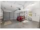Spacious garage features a lawnmower, bicycle, overhead lighting and storage, offering ample space at 8851 Sw 116Th Street Rd, Ocala, FL 34481