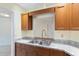 Kitchen featuring granite counters, wood cabinets, and a stainless steel sink with a pass-through to another room at 8851 Sw 116Th Street Rd, Ocala, FL 34481