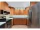 Image displays a kitchen with stainless steel appliances, wooden cabinetry, and granite countertops at 8851 Sw 116Th Street Rd, Ocala, FL 34481