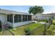 View of the screened-in lanai and fenced backyard with a well-maintained lawn at 8851 Sw 116Th Street Rd, Ocala, FL 34481