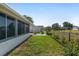 View of the home's screened-in lanai and fenced backyard area with lush grass at 8851 Sw 116Th Street Rd, Ocala, FL 34481