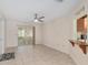 Open living area with tile floors, ceiling fan, and a kitchen pass-through, perfect for entertaining at 8851 Sw 116Th Street Rd, Ocala, FL 34481