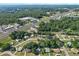Aerial view of a residential neighborhood with lush greenery, showcasing its convenient location near shops and roads at 8954 Sw 104Th Ln, Ocala, FL 34481