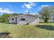 Back view of home featuring vinyl siding, a large backyard with a basketball hoop, and clear blue skies at 8954 Sw 104Th Ln, Ocala, FL 34481