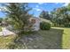 The back of the house is shown from the side yard, with large tree and white lattice siding at 8954 Sw 104Th Ln, Ocala, FL 34481