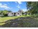 A view of the back of the house, showcasing the yard with a well-maintained lawn and trees at 8954 Sw 104Th Ln, Ocala, FL 34481