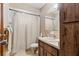 Bathroom featuring a shower-tub combo, a single sink vanity, and wood-grain cabinets at 8954 Sw 104Th Ln, Ocala, FL 34481