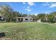 View of the house exterior and yard, showing a well-maintained lawn and a screened porch at 8954 Sw 104Th Ln, Ocala, FL 34481