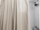 Close-up of a shower with white tiled walls and neutral shower curtain at 8954 Sw 104Th Ln, Ocala, FL 34481