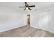 Bedroom featuring wood-look flooring, a ceiling fan, and closet with a view to the kitchen at 9320 Sw 89Th Ter # C, Ocala, FL 34481