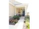 Inviting front porch area, featuring stone accents, decorative plants, seating, and a stylish front door at 9764 Sw 100Th Avenue Rd, Ocala, FL 34481