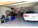 Spacious two-car garage featuring a white car, tools, and ample storage space at 9764 Sw 100Th Avenue Rd, Ocala, FL 34481