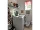 Functional laundry room with modern appliances, storage shelves, and a bright window at 9764 Sw 100Th Avenue Rd, Ocala, FL 34481